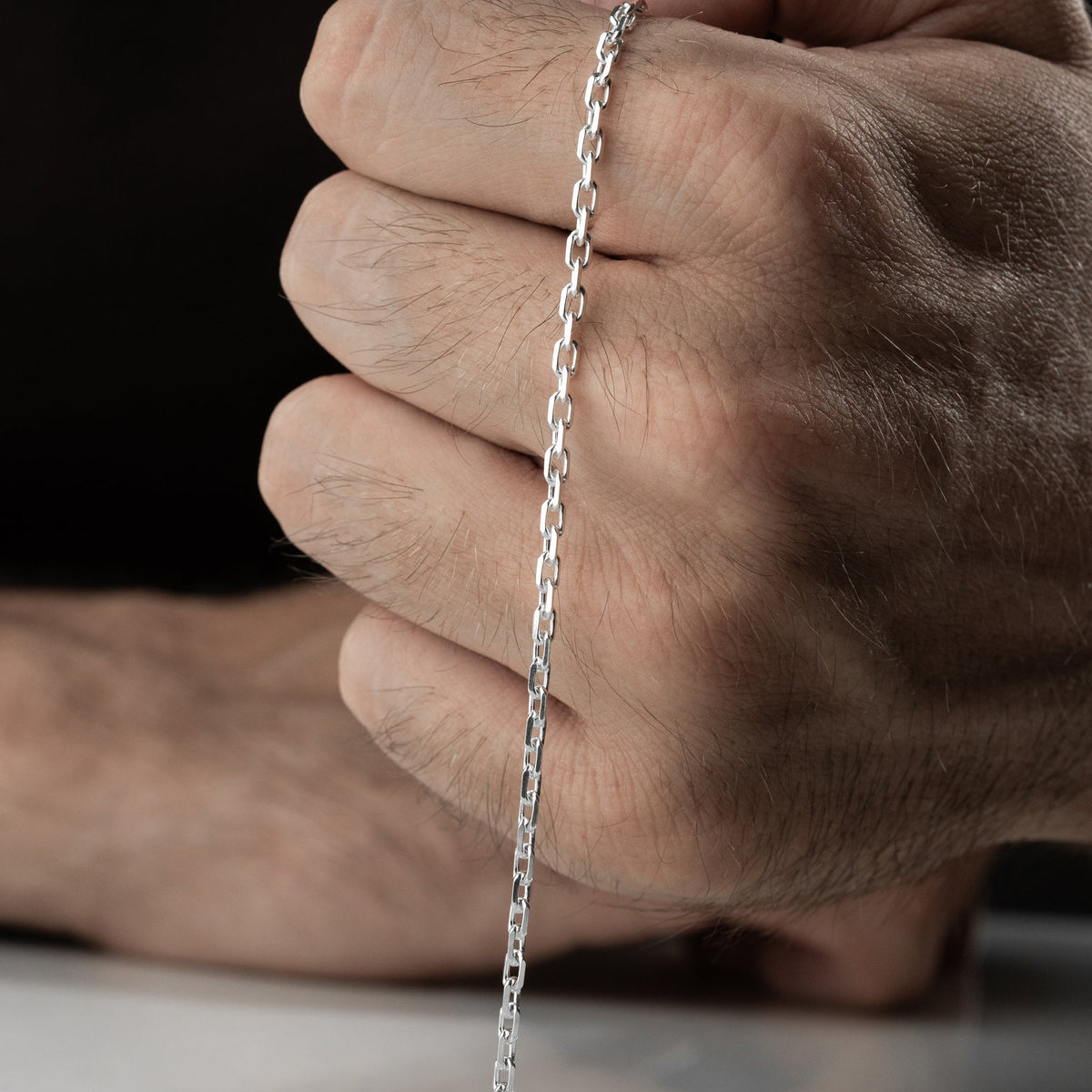 4 mm forse zincir erkek bileklik, elde yakın görünümü.
