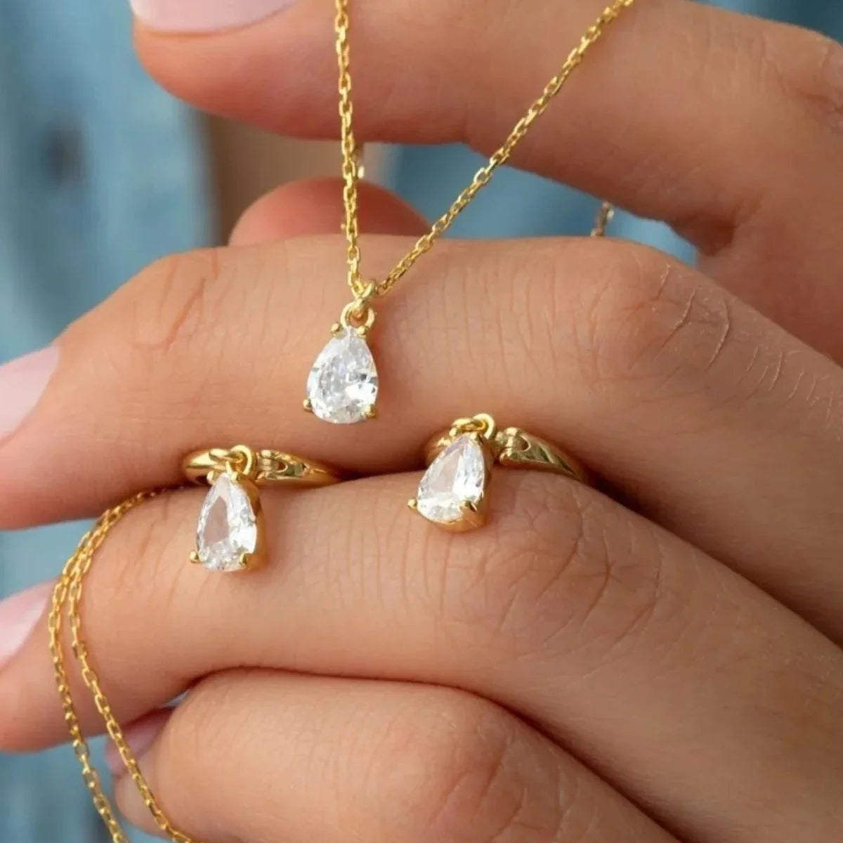 Damla taşlı kolye-küpe set, elde yakın görünümü.