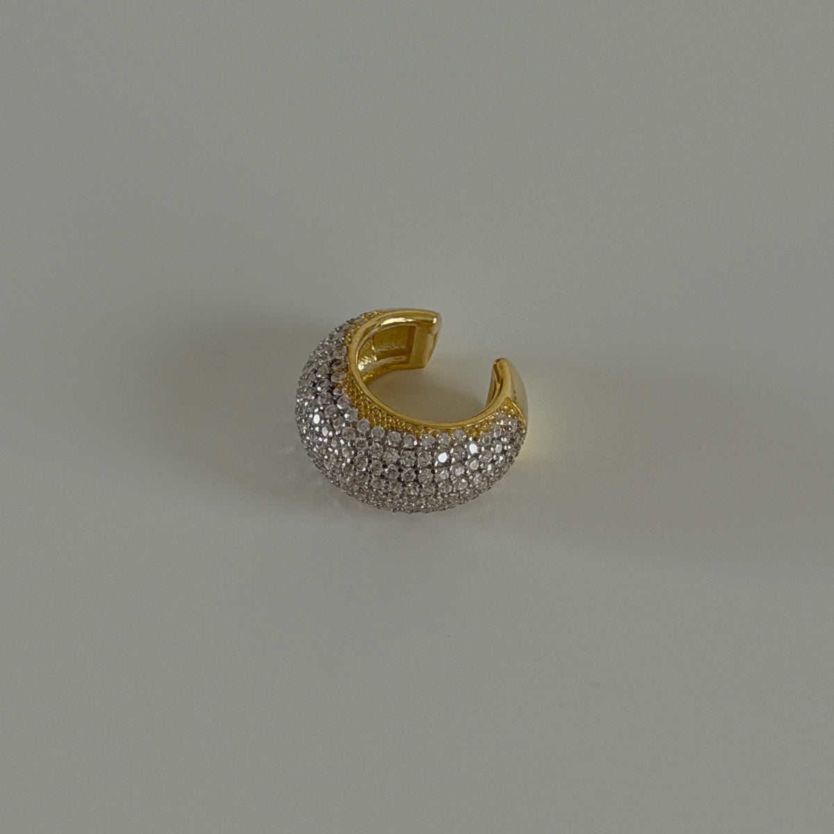 Full taşlı oval earcuff kıkırdak küpe, zemin üzerinde görünümü.