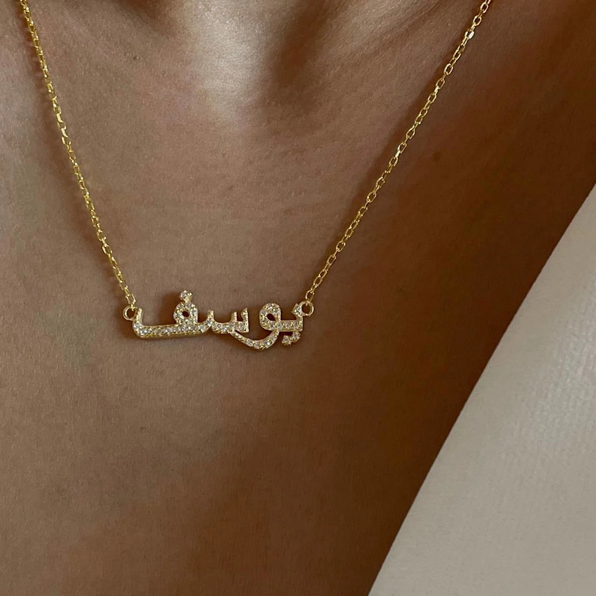 Kişiye özel arapça isim yazılı zirkon taşlı kolye, boyunda kullanımı.