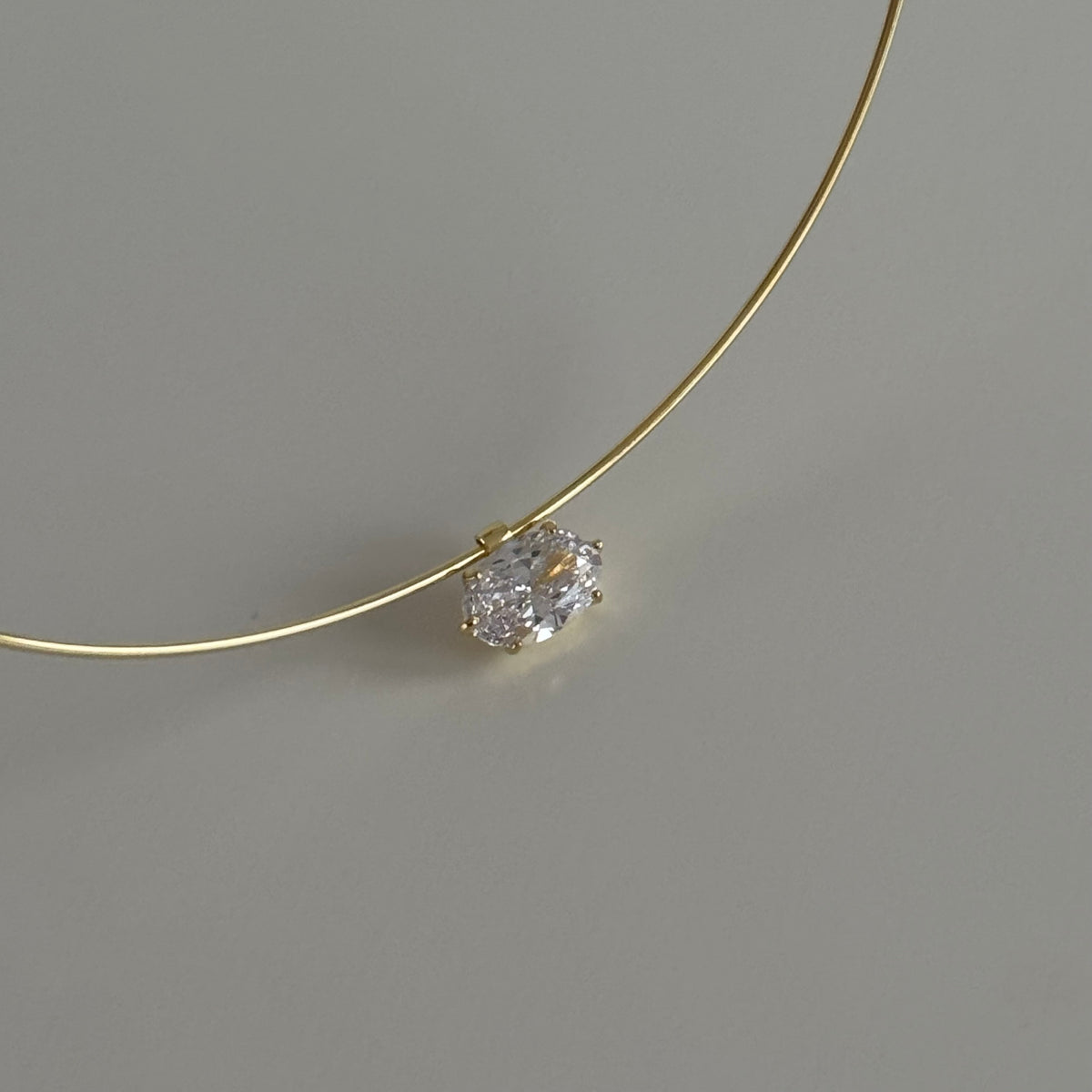 Oval taşlı choker kolye, zemin üzerinde görünümü.