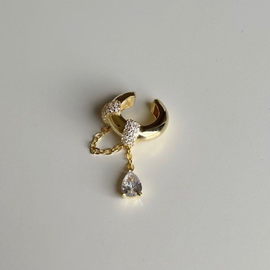 Zirkon taşlı damla sallantılı earcuff kıkırdak küpe, zemin üzerinde görünümü.