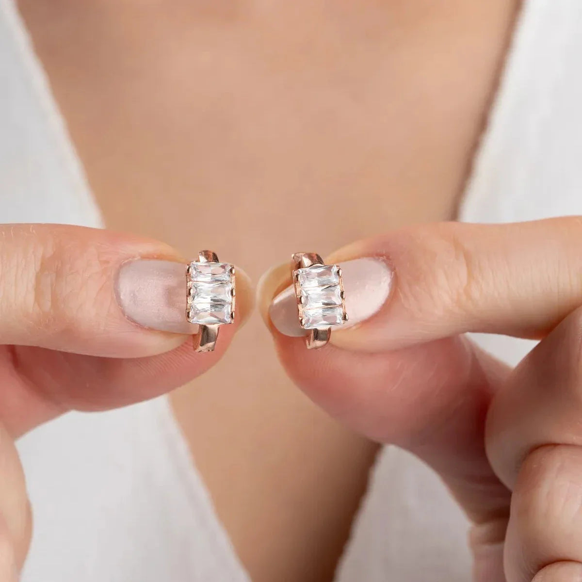 Baget taşlı halka tasarım küpe, elde yakın görünümü.