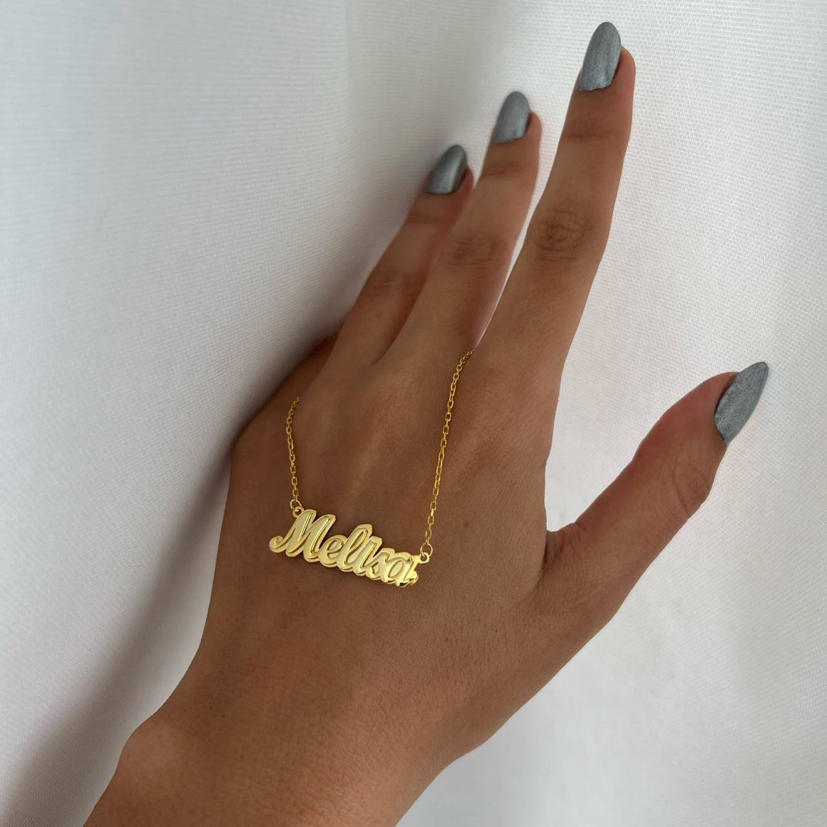 Kişiye özel simli ışıltılı kolye, elde yakın görünümü.