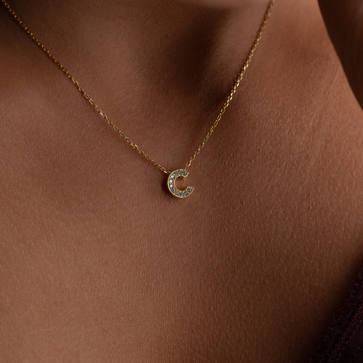 Kişiye özel zirkon taşlı minimal harf kolye, boyunda kullanımı.